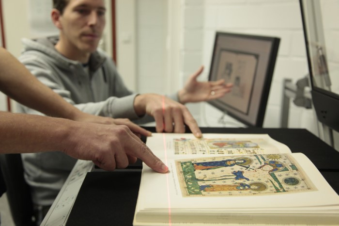 Studiengangsbild, zeigt Menschen beim Scannen, Digitalisieren einer alten Handschrift.